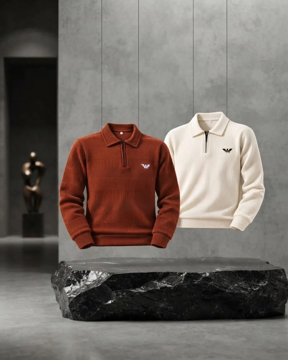Two floating knit sweaters in rust and cream above a black marble slab in a modern concrete room