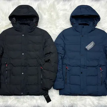 Two black and navy blue puffer jackets with red zippers on white fur background