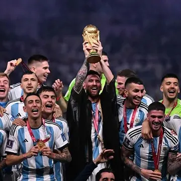 Argentina soccer team holding World Cup trophy celebrating victory with fans