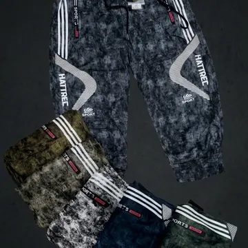 Five floating tie-dye sport pants in various colors with brand logos against a dark gray background
