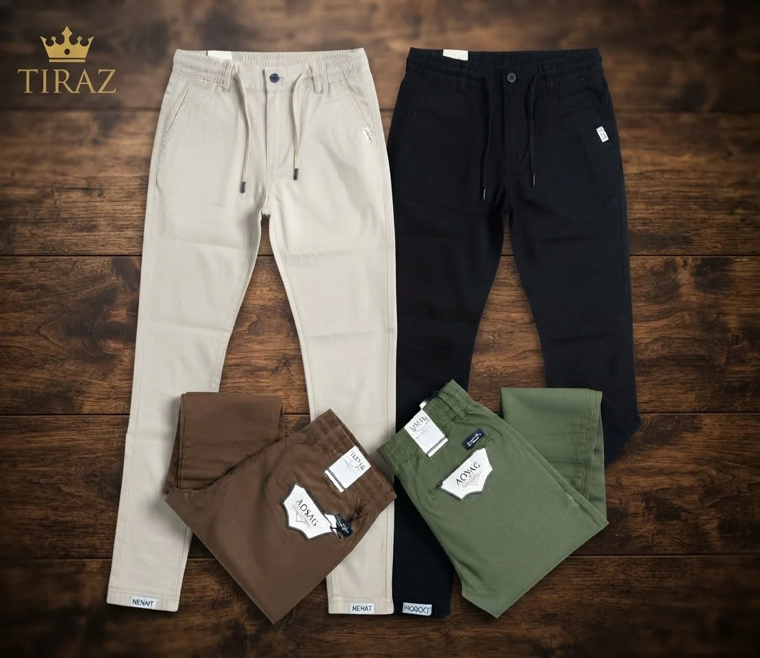Four pairs of men's trousers in beige black brown and olive green on wooden floor