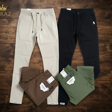 Four pairs of men's trousers in beige black brown and olive green on wooden floor