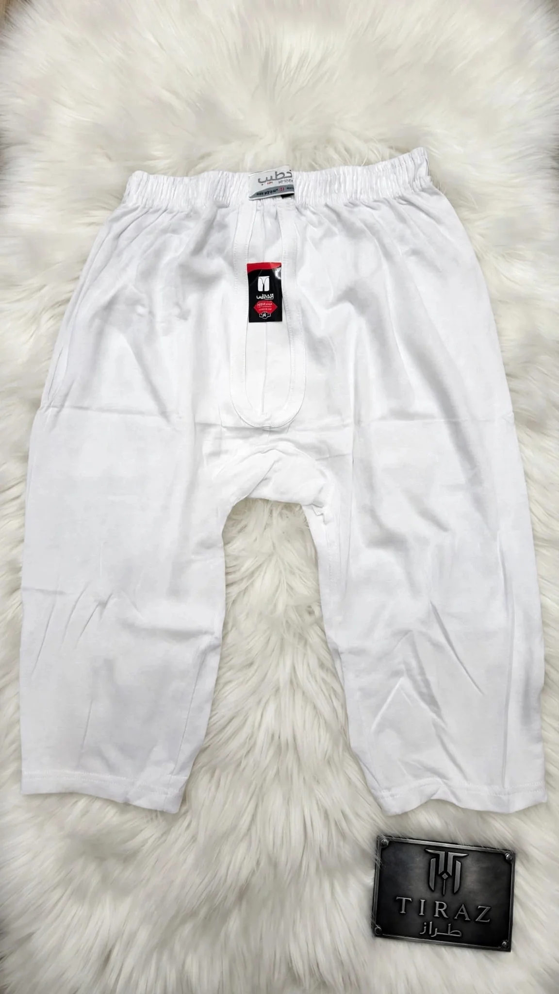 White men's boxer briefs with brand tags on fluffy white fur background
