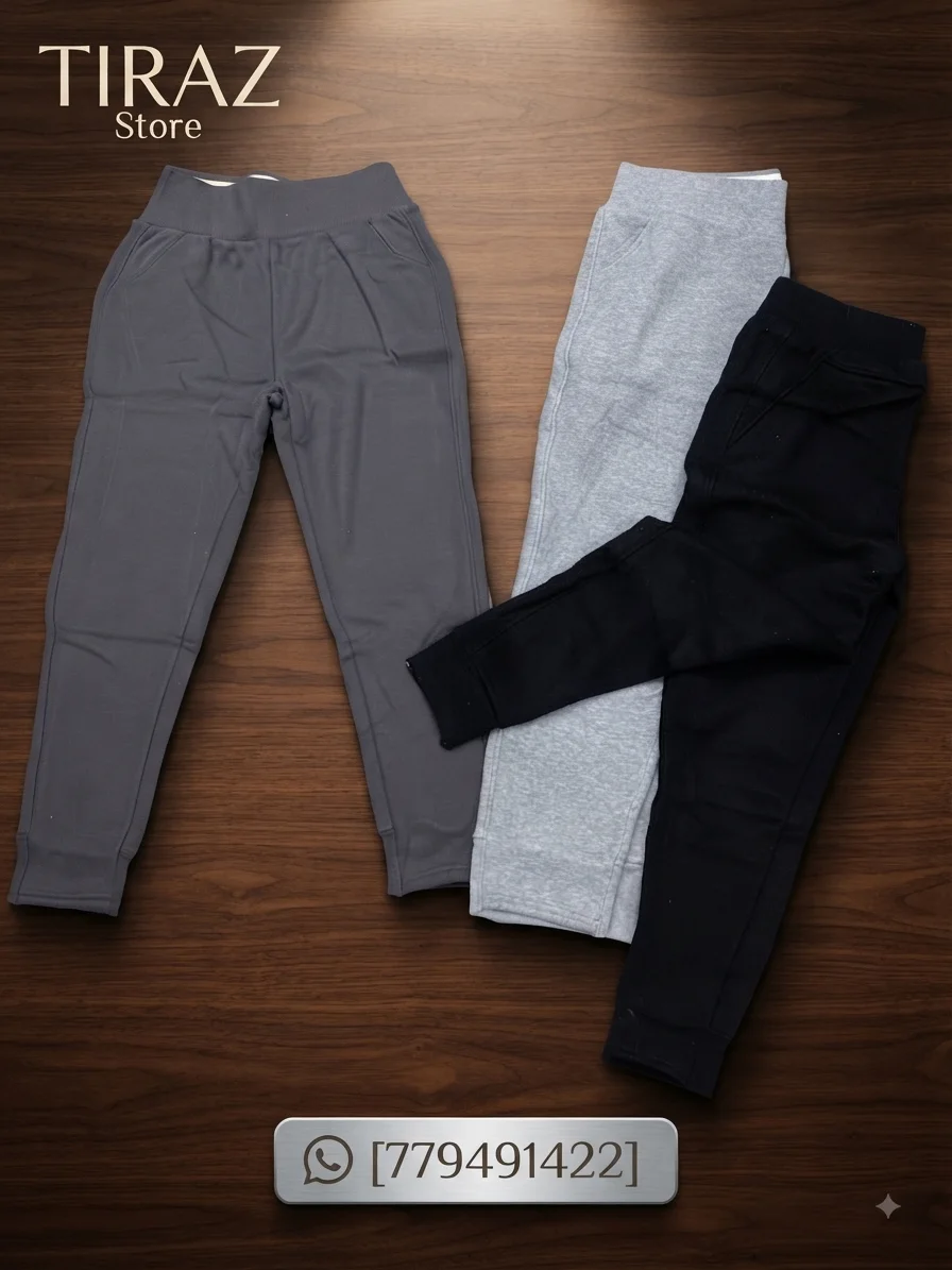 Three pairs of children's joggers in gray black and heather gray on a wooden surface