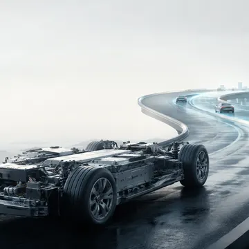 Futuristic electric car chassis on a glowing highway near a city and ocean