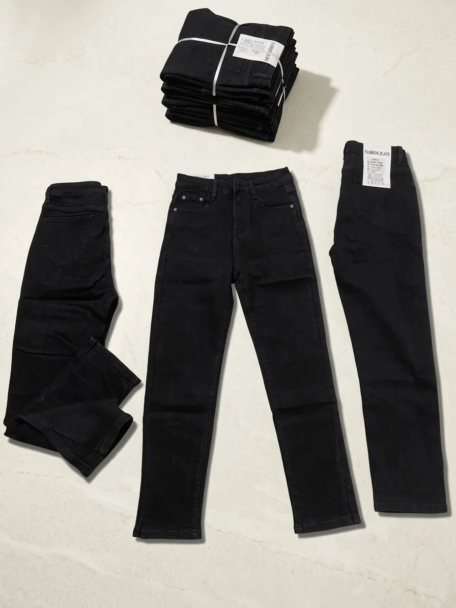 Black denim jeans arranged on a marble surface including folded and laid out styles with visible labels