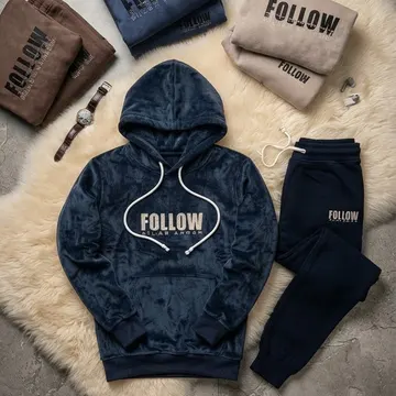 A navy velvet hoodie and joggers with 'FOLLOW' branding arranged on a fluffy rug with accessories
