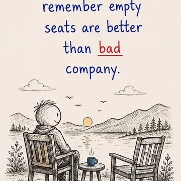 A person sits alone by a lake at sunset with an empty chair beside them and a steaming mug on a table
