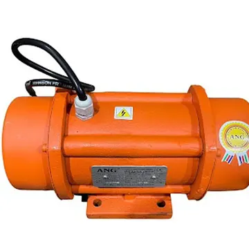 Orange industrial vibratory motor with black cable and warning labels