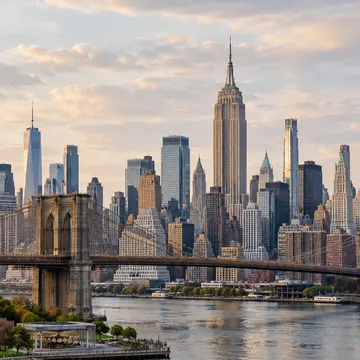 Brooklyn Bridge with NYC skyline and river at golden hour