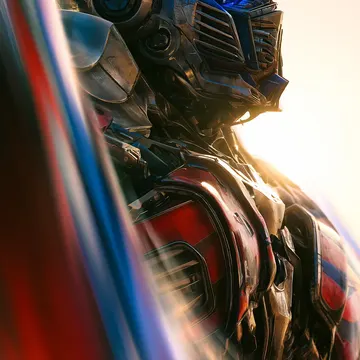 Optimus Prime in detailed armor with glowing blue eyes against a bright sunlit background