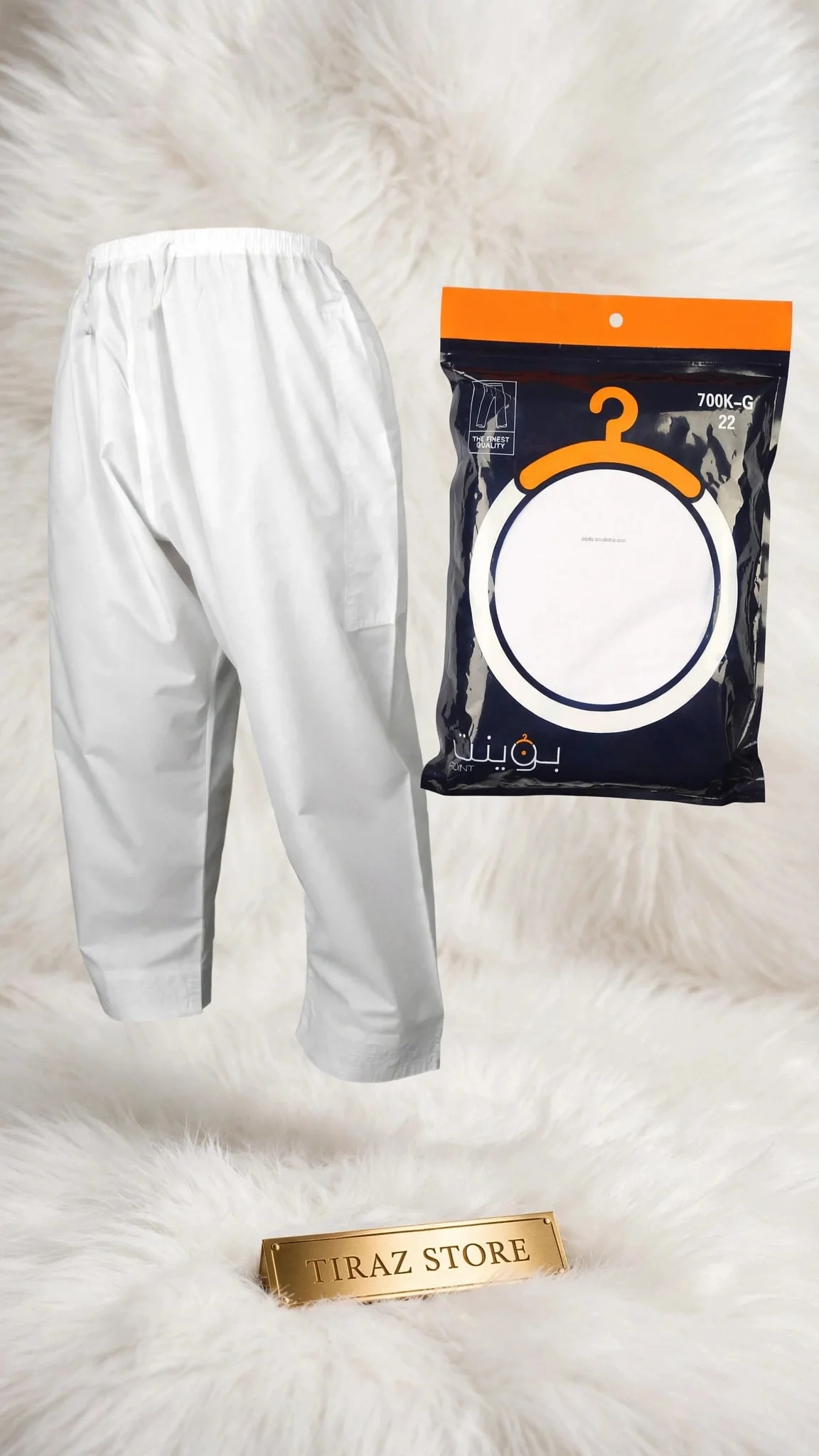 White pants and packaged pants displayed on fluffy white fur with gold store plaque