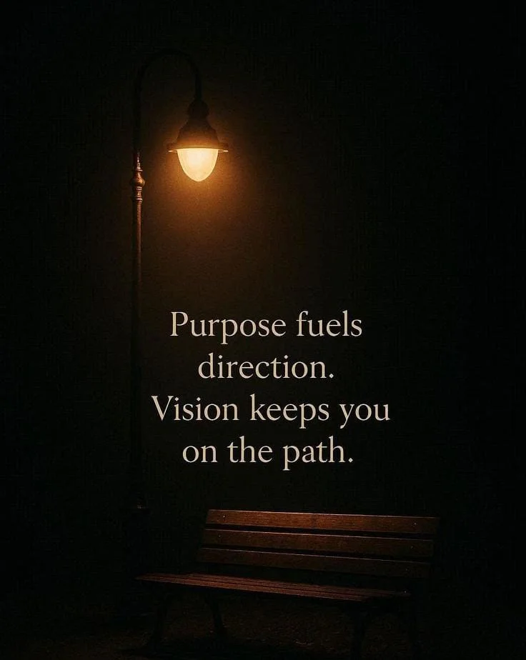 A wooden bench under a lit streetlamp at night with motivational text